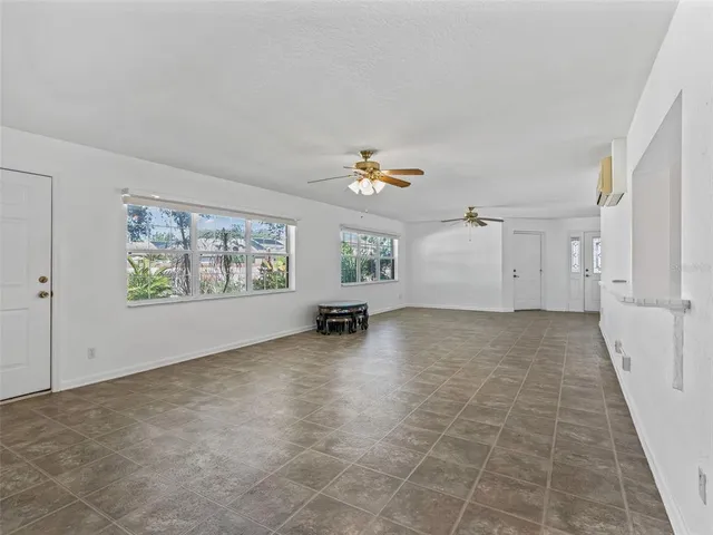 an empty room with windows and fireplace