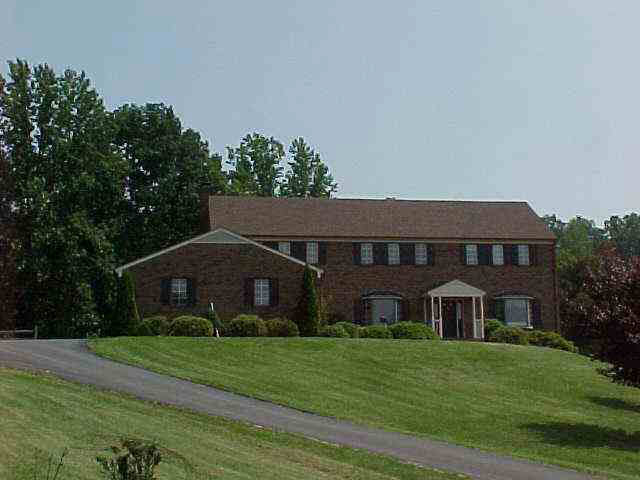 1717 Lambs Road Charlottesville, VA 22901 - Photo 3 of 4 a view of a big house with a big yard and large trees