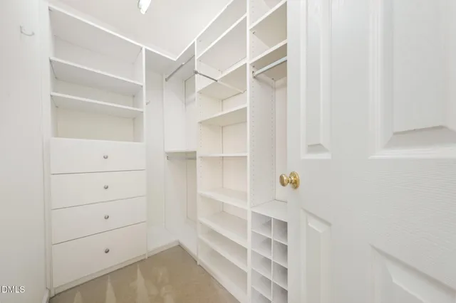 a view of walk in closet with empty racks