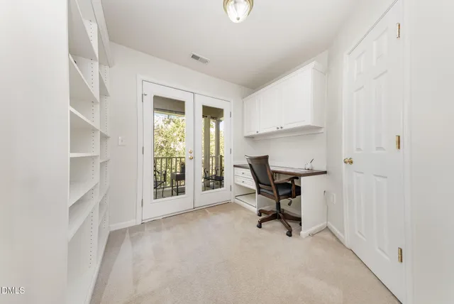 a view of a workspace with furniture and a window