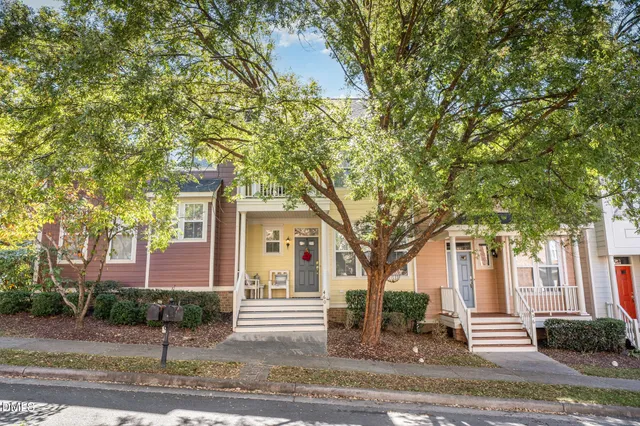 a front view of a house with a tree