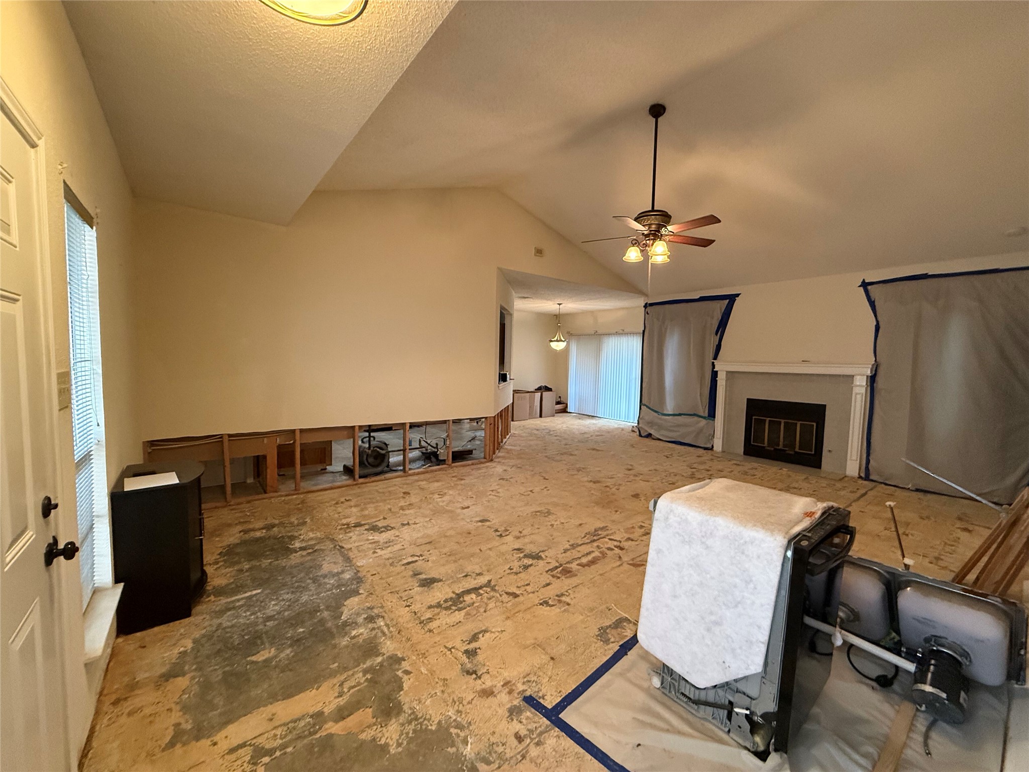 11816 Bittern Hollow Austin, TX 78758 - Photo 15 of 30 Spacious interior featuring a vaulted ceiling, ceiling fan with integrated lighting, and a fireplace with a decorative mantel