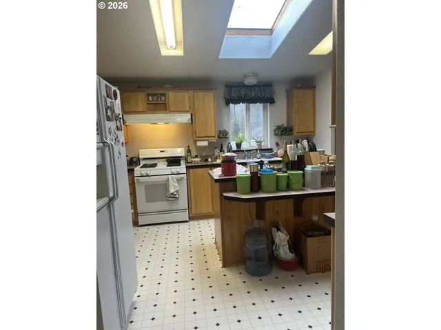 a kitchen with a sink a stove top oven and cabinetry