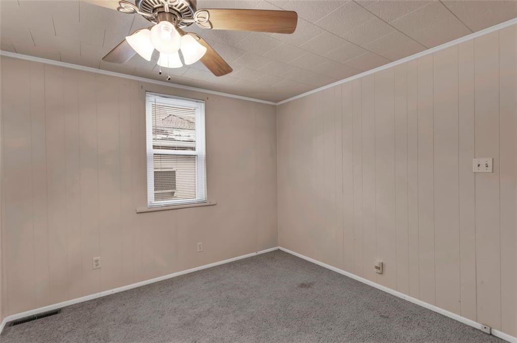 323 Sycamore Street Vandergrift, PA 15690 - Photo 14 of 28 an empty room with a chandelier fan and windows