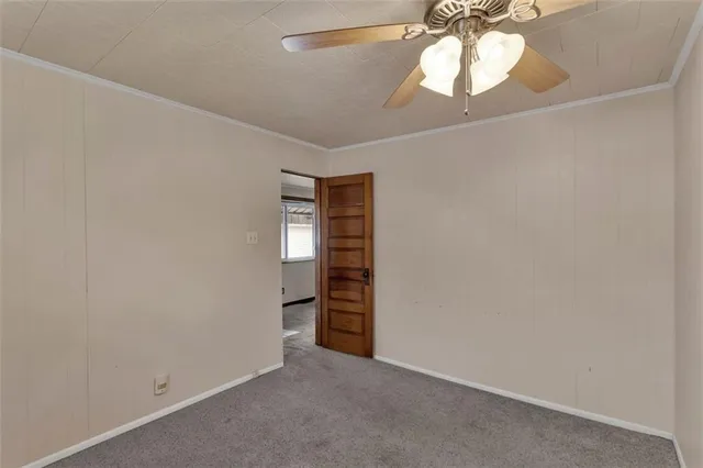 an empty room with a fan and a window