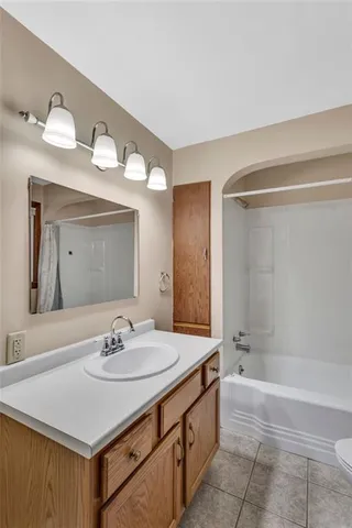 a bathroom with a sink vanity granite tub and a mirror