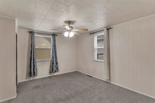 an empty room with chandelier fan