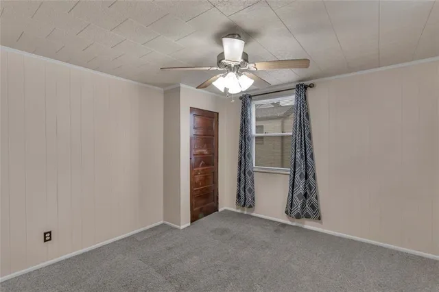 an empty room with closet and a chandelier fan