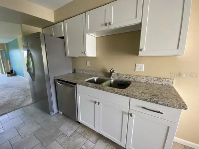 a kitchen with stainless steel appliances granite countertop a sink a stove and cabinets
