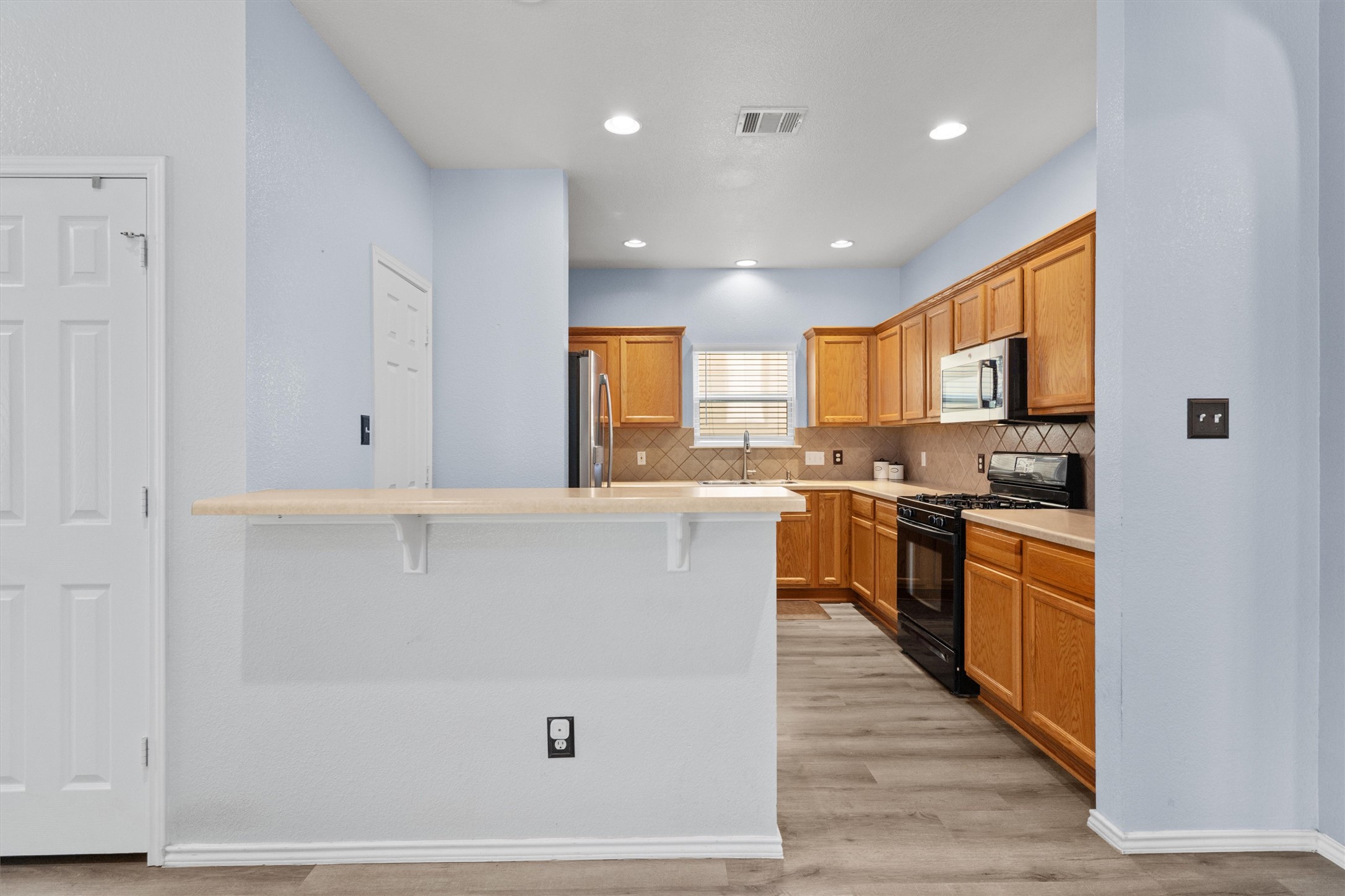 1833 Thompson Trail Round Rock, TX 78664 - Photo 8 of 40 A well-lit kitchen featuring warm wood cabinetry and durable vinyl flooring.