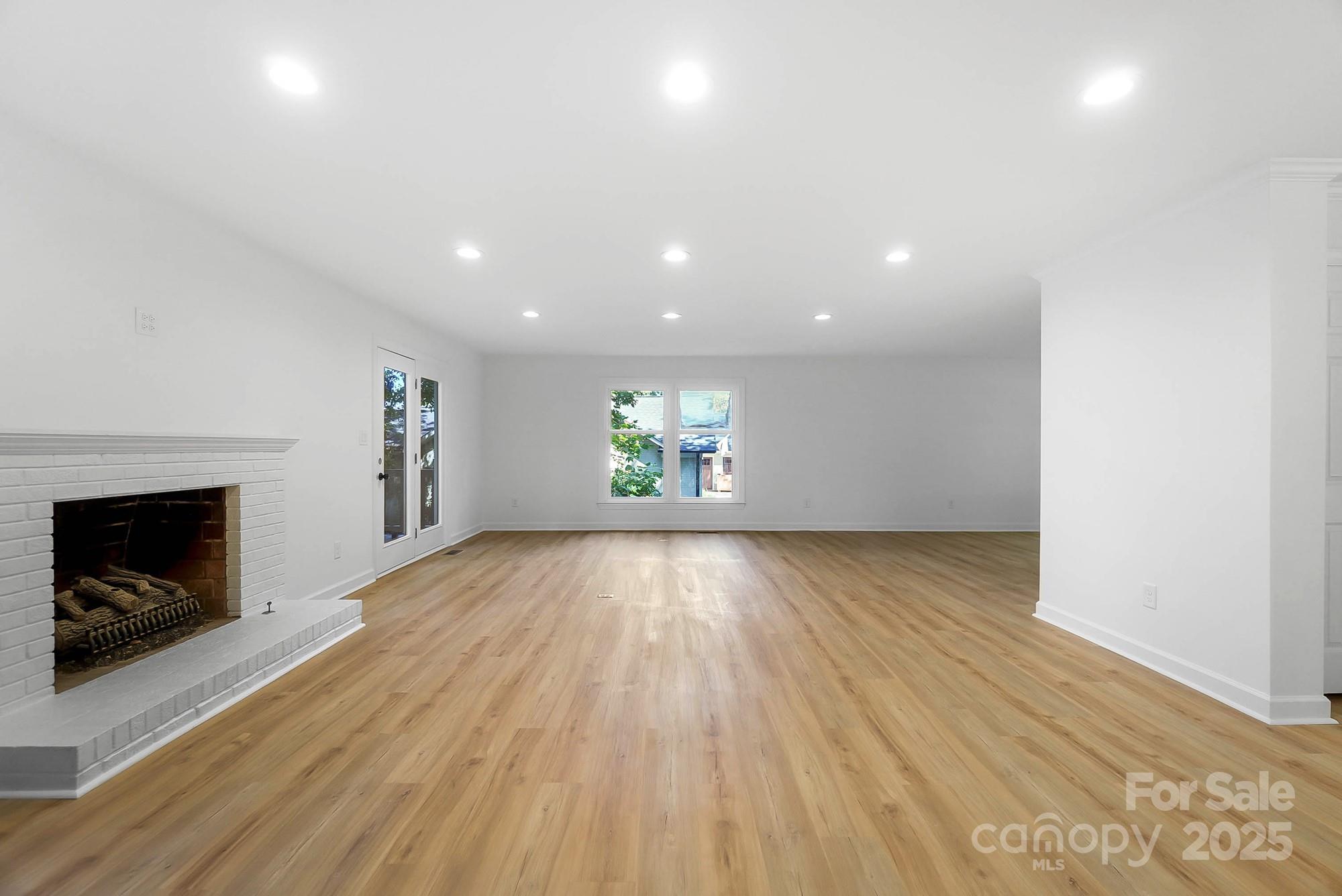 3323 Lincoln Lane Gastonia, NC 28056 - Photo 11 of 47 an empty room with wooden floor and fireplace