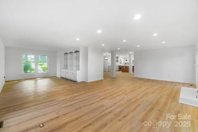 a view of empty room with wooden floor and windows