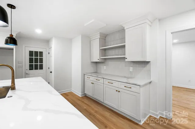 a kitchen with stainless steel appliances granite countertop a stove a sink and white cabinets