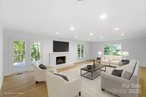 a living room with fireplace furniture and a large window