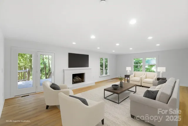 a living room with fireplace furniture and a large window