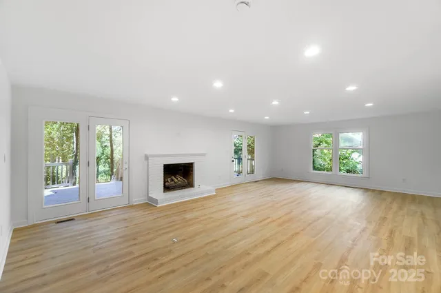 an empty room with windows and a fireplace