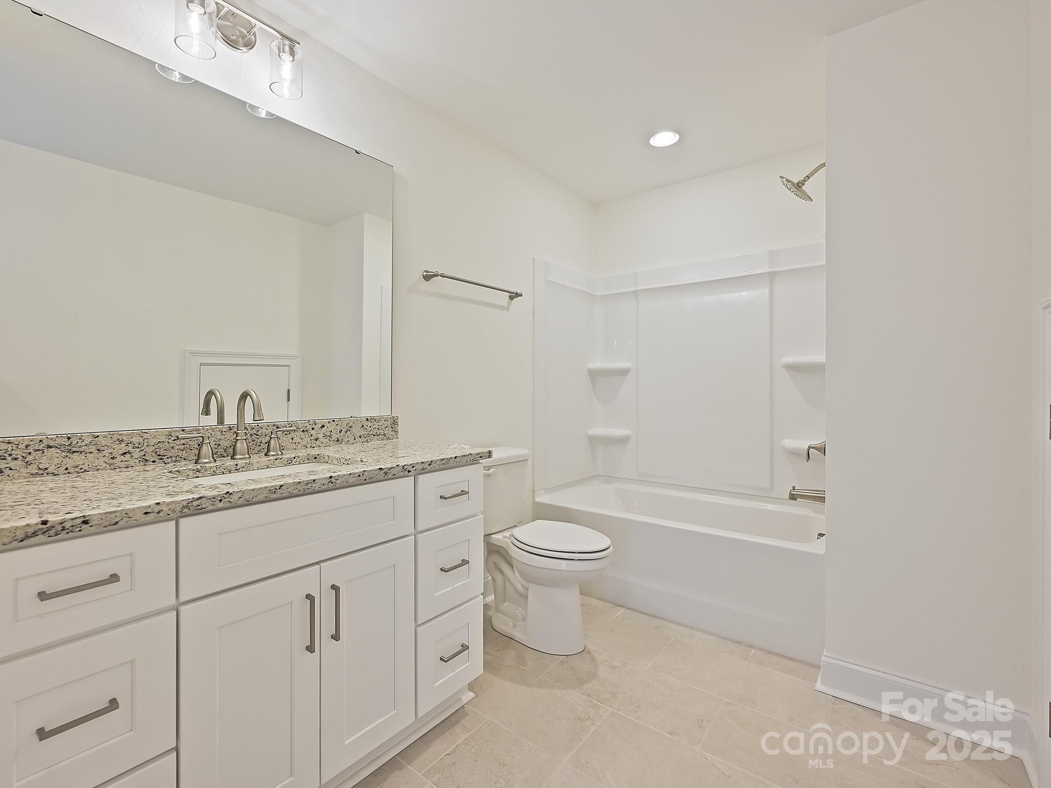 215 Triple Ponds Court Clover, SC 29710 - Photo 26 of 32 a bathroom with a granite countertop toilet a sink and a bathtub