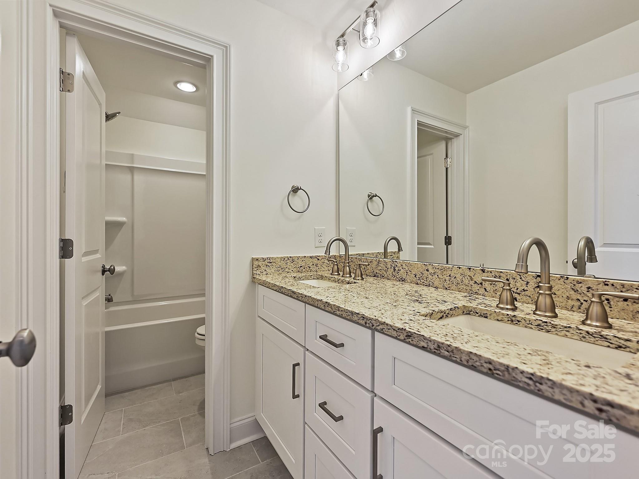 215 Triple Ponds Court Clover, SC 29710 - Photo 28 of 32 a bathroom with a granite countertop sink a mirror and a