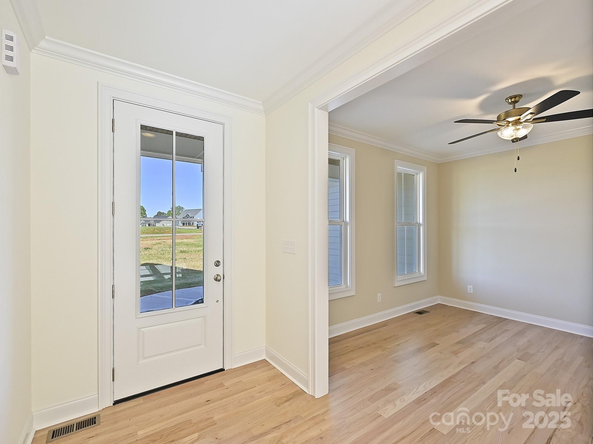 215 Triple Ponds Court Clover, SC 29710 - Photo 3 of 32 an empty room with wooden floor cabinet and windows