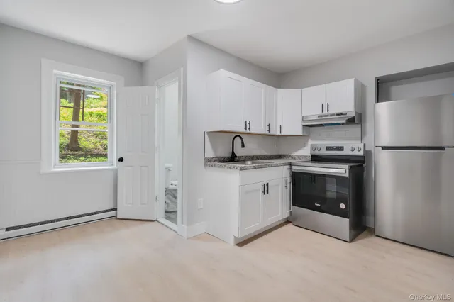 a kitchen with stainless steel appliances granite countertop a refrigerator sink and stove