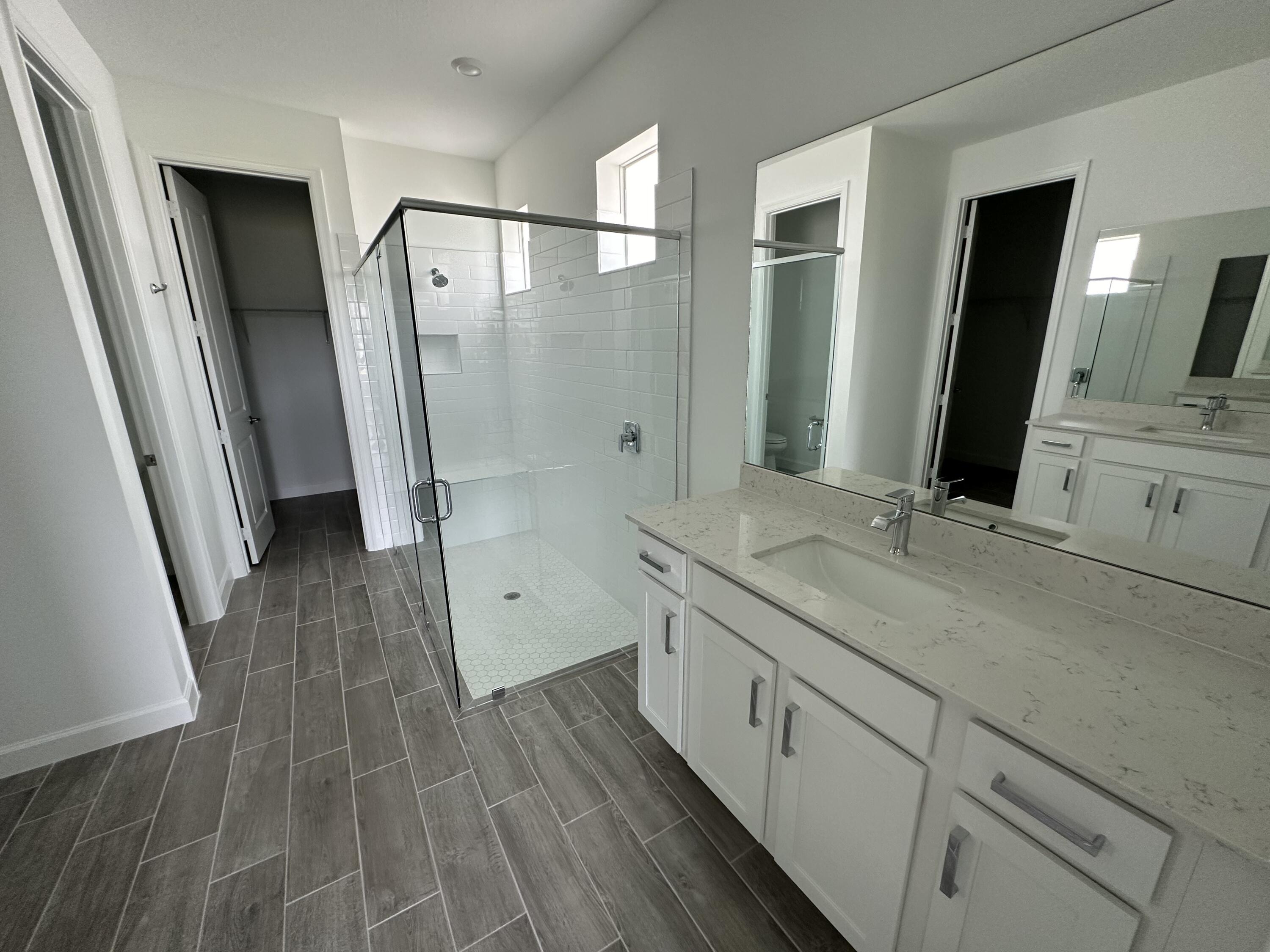 19046 Croft Mill Crossing Loxahatchee, FL 33470 - Photo 12 of 22 a spacious bathroom with a double vanity sink a large mirror a shower and a bathtub