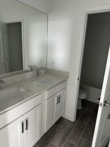 a bathroom with a granite countertop sink and a mirror