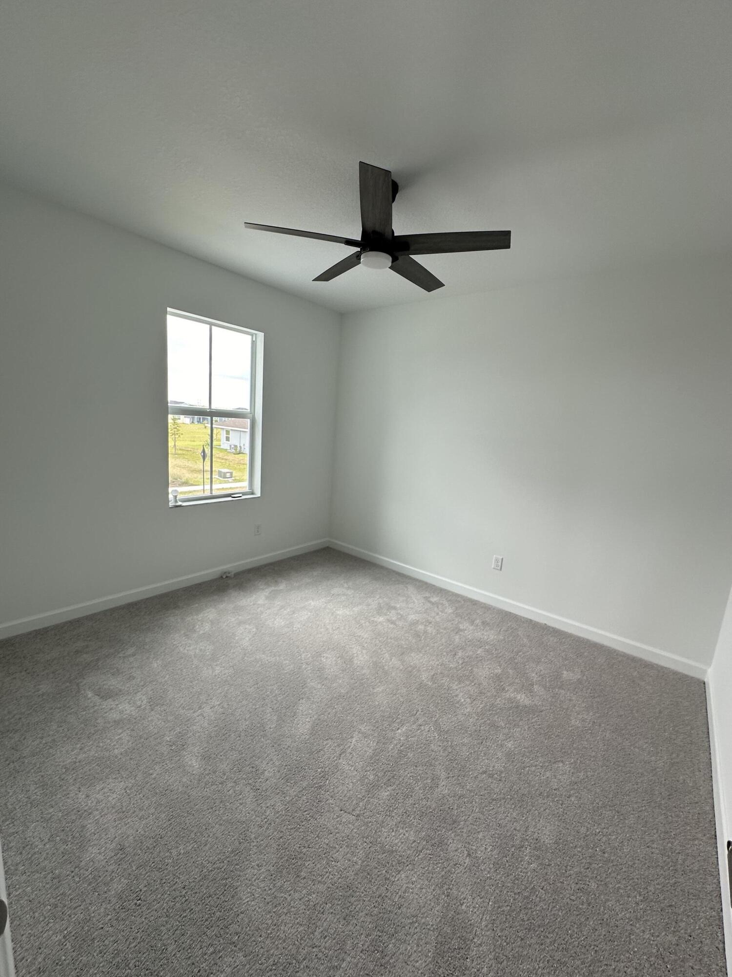 19046 Croft Mill Crossing Loxahatchee, FL 33470 - Photo 21 of 22 an empty room with windows and chandelier fan