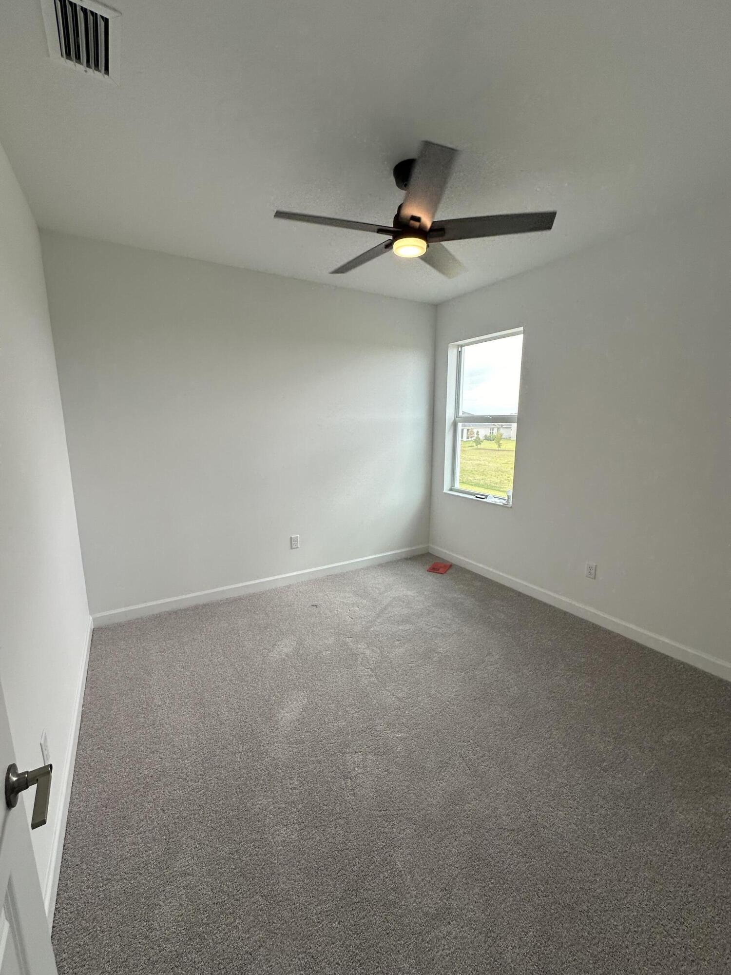 19046 Croft Mill Crossing Loxahatchee, FL 33470 - Photo 22 of 22 an empty room with a window and ceiling fan
