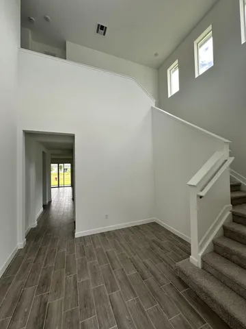 a view of a hallway with wooden floor and staircase