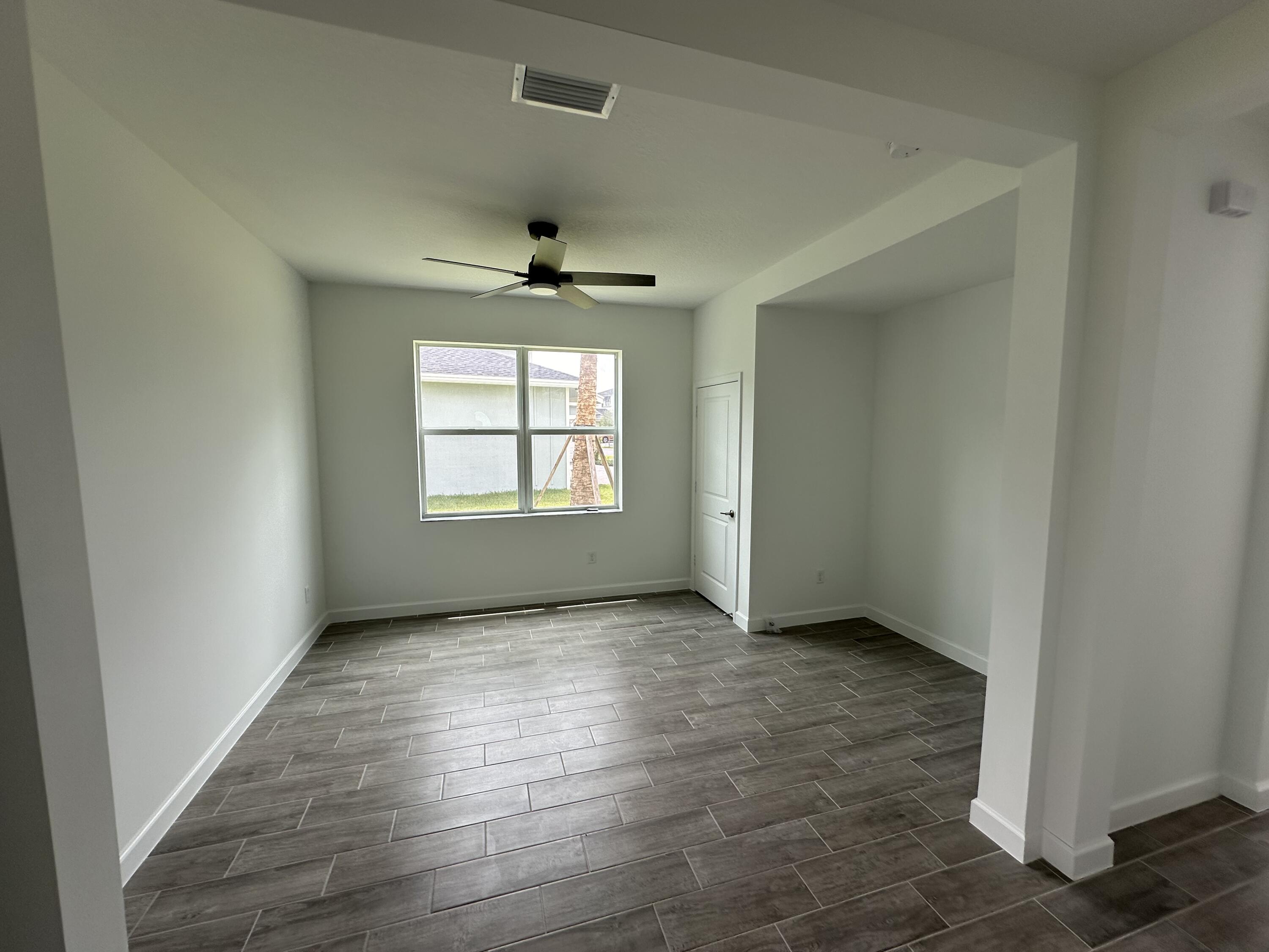 19046 Croft Mill Crossing Loxahatchee, FL 33470 - Photo 5 of 22 an empty room with wooden floor chandelier and windows