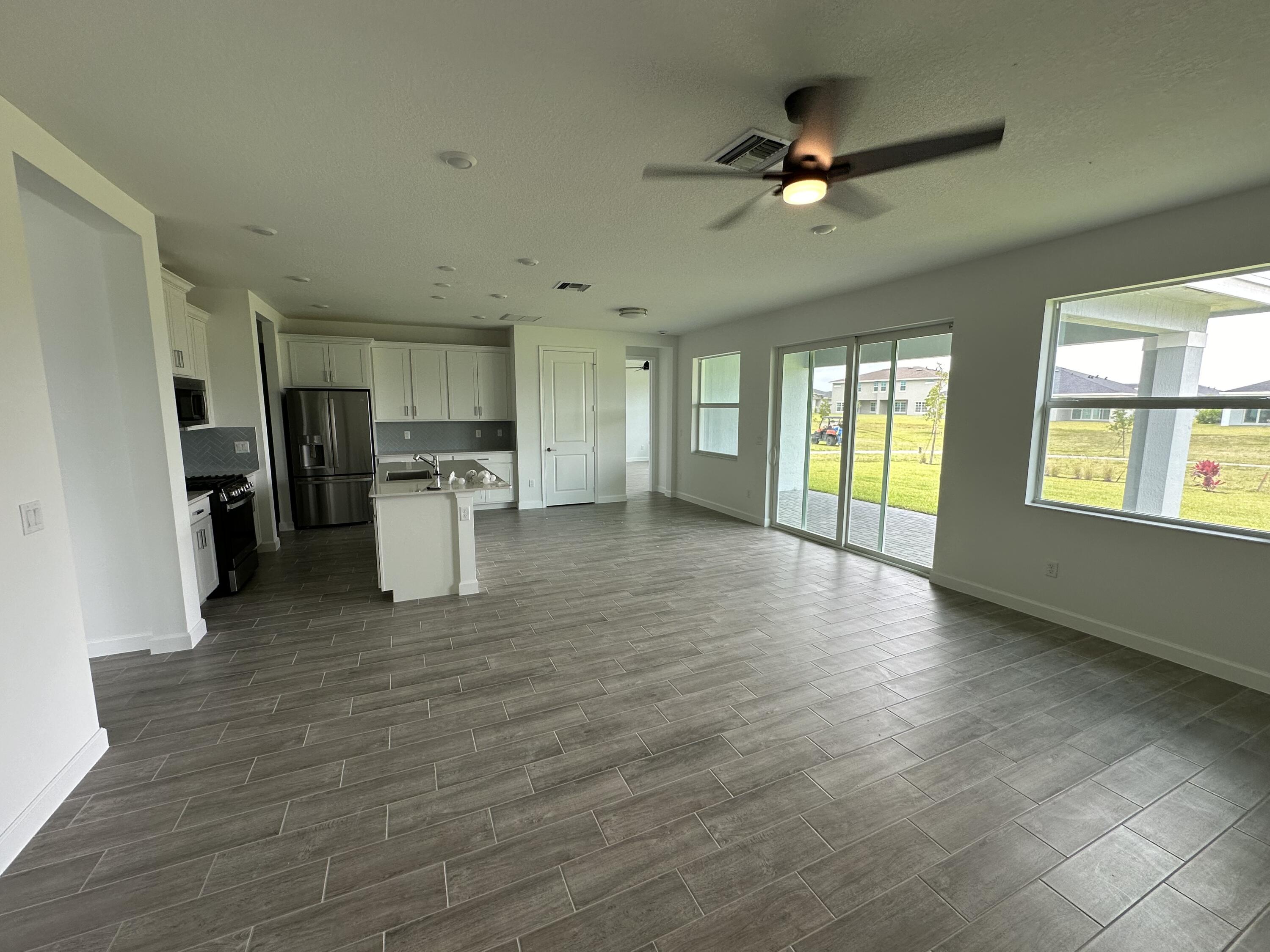 19046 Croft Mill Crossing Loxahatchee, FL 33470 - Photo 6 of 22 a view of an empty room with a window and kitchen view