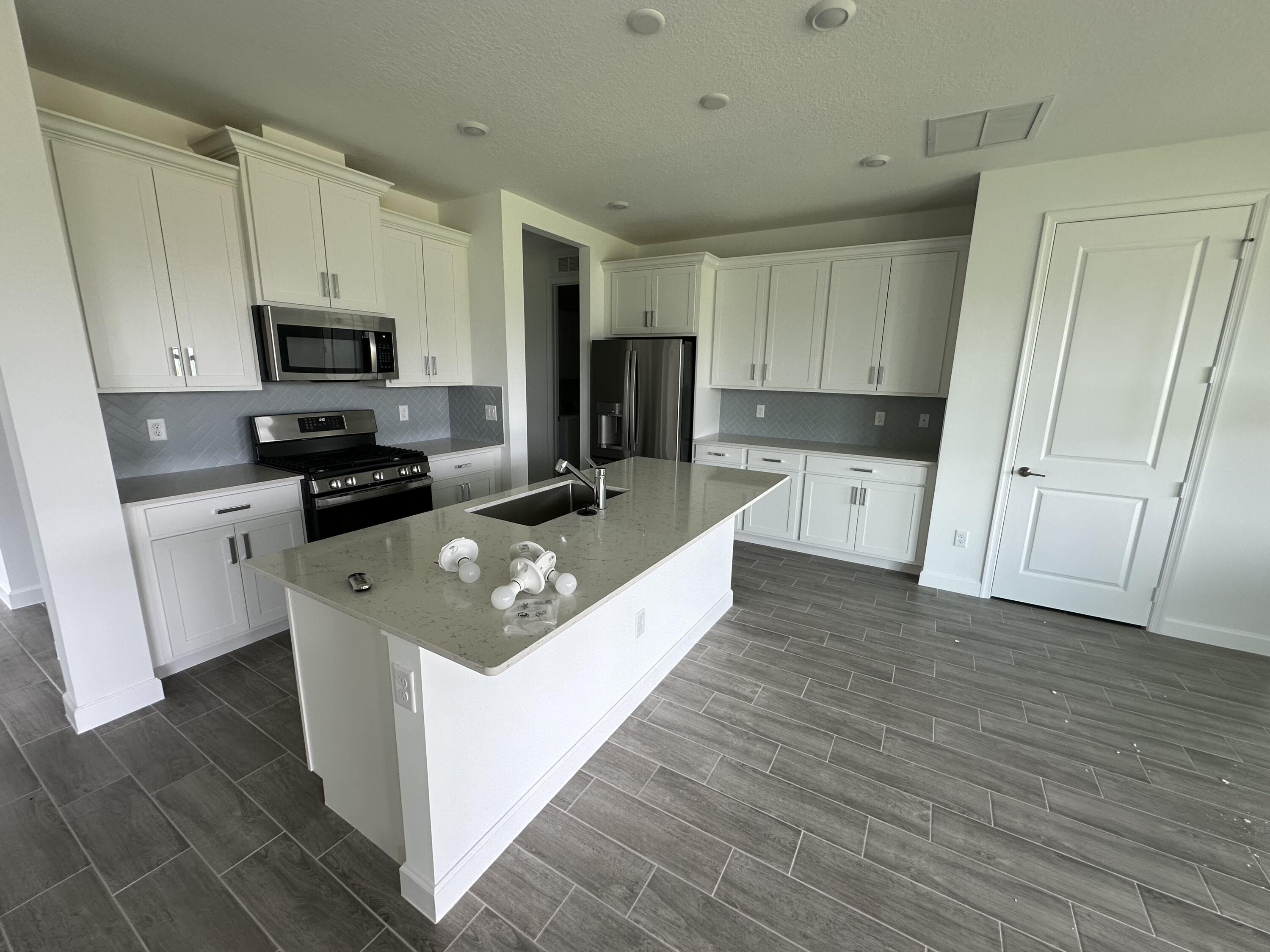 19046 Croft Mill Crossing Loxahatchee, FL 33470 - Photo 7 of 22 a large kitchen with stainless steel appliances granite countertop a stove a sink and a refrigerator