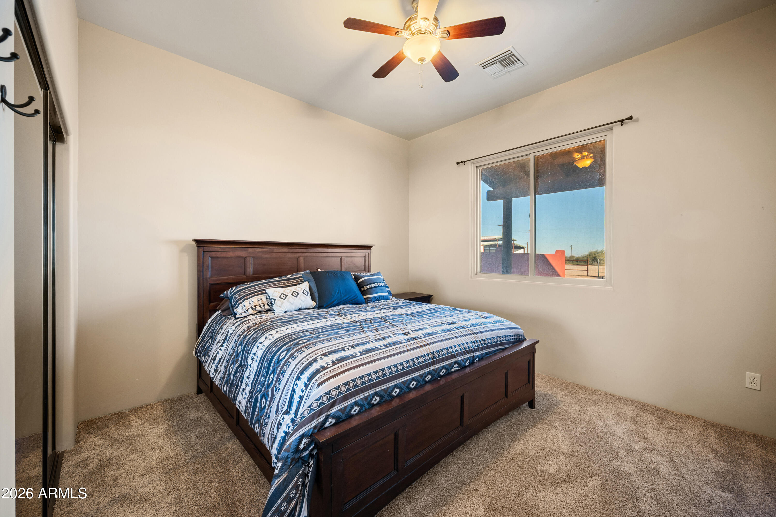 8679 North Warren Road Maricopa, AZ 85139 - Photo 15 of 40 a bedroom with a bed and a chandelier