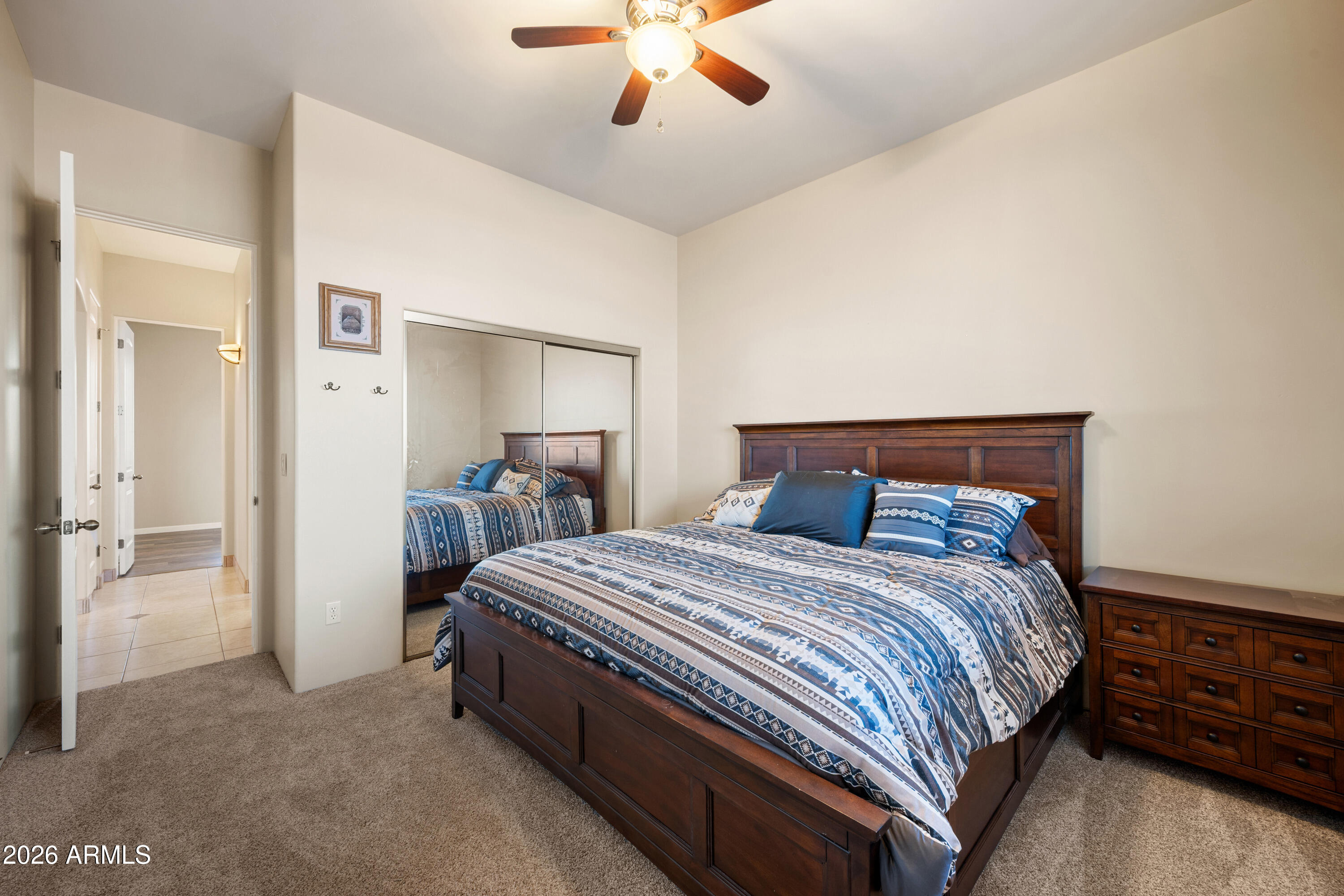 8679 North Warren Road Maricopa, AZ 85139 - Photo 16 of 40 a bedroom with a bed and a chandelier