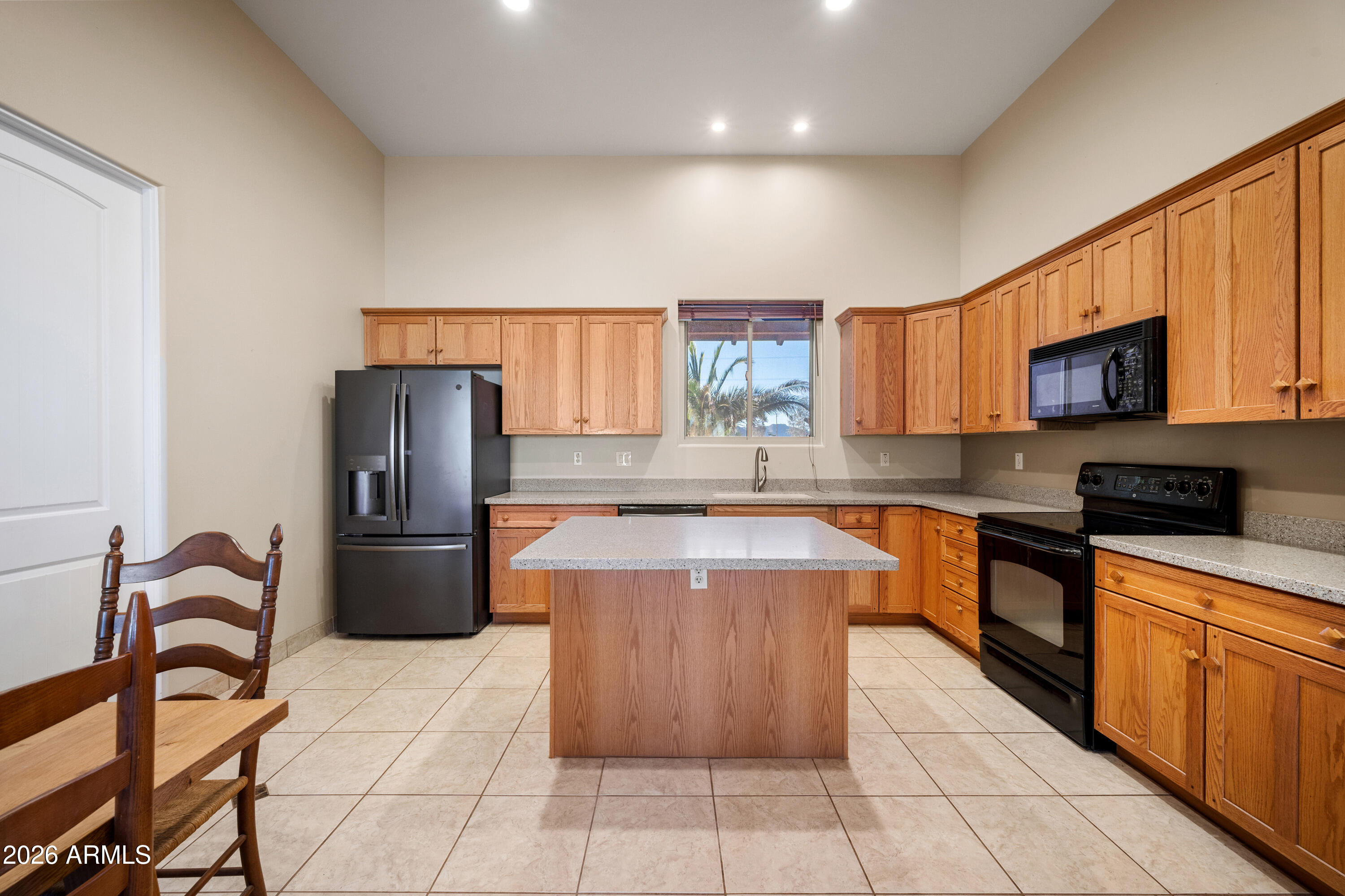 8679 North Warren Road Maricopa, AZ 85139 - Photo 7 of 40 a kitchen with a refrigerator a stove a sink a dining table and chairs