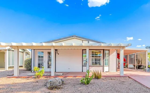 a view of a house with large windows and plants