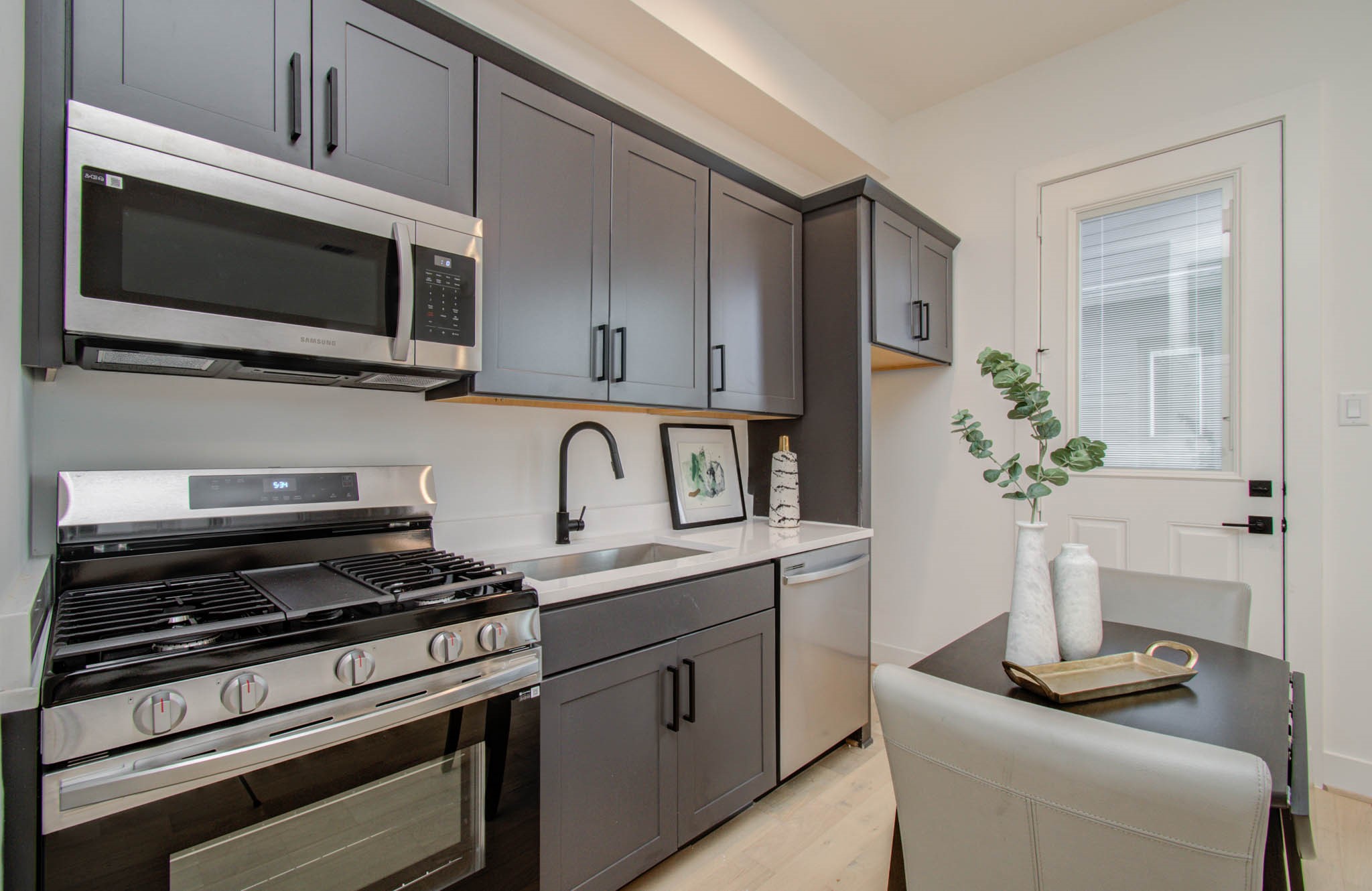 3008 Lamar Street Houston, TX 77003 - Photo 10 of 33 First level bedroom is its own rentable studio apartment featuring a private laundry closet, full sized gas stove, vented microwave, sink, full-sized dish washer and a fridge.