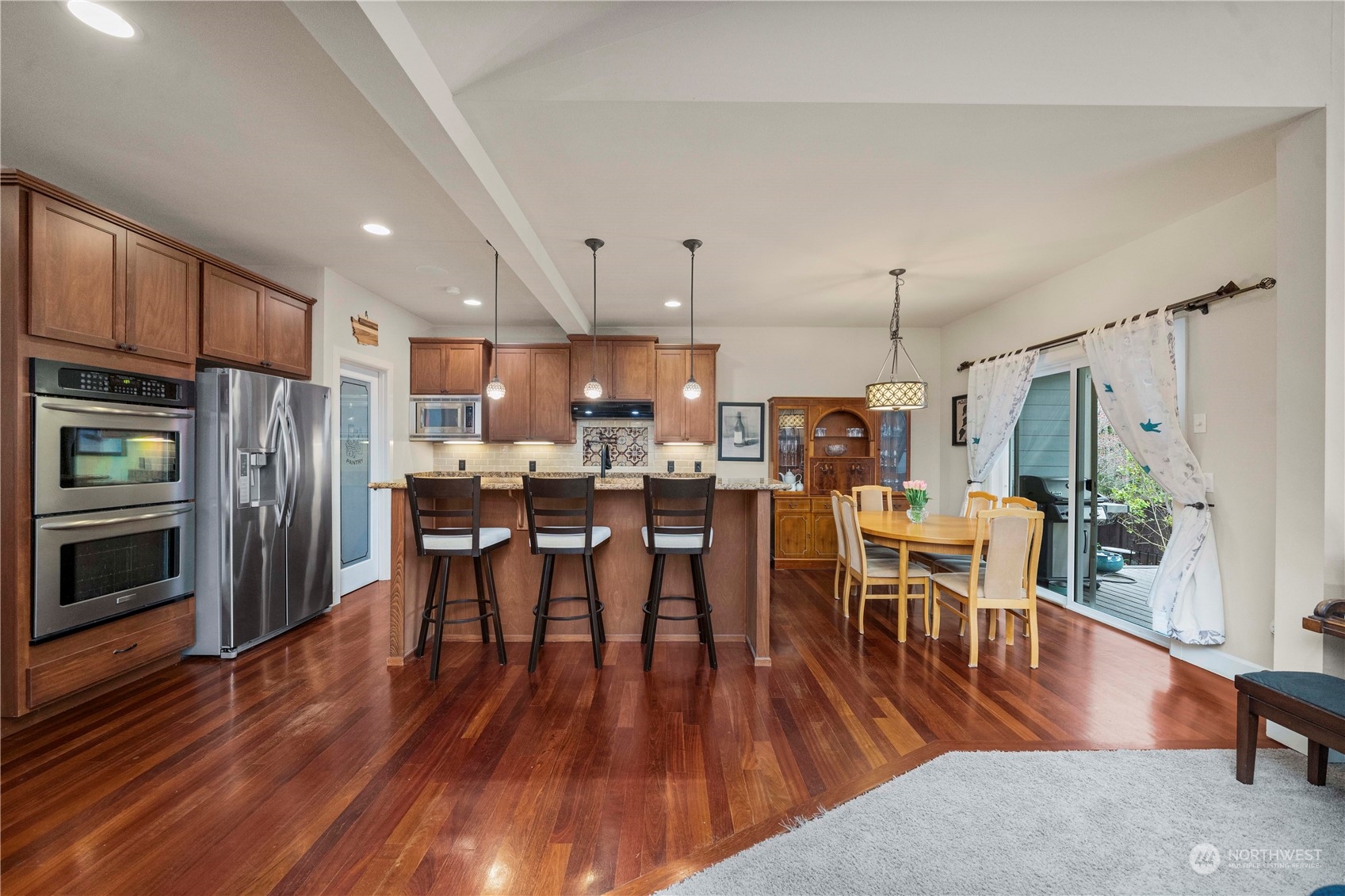 6765 Southeast 2nd Street Renton, WA 98059 - Photo 8 of 36 a kitchen with stainless steel appliances a dining table chairs stove refrigerator and cabinets