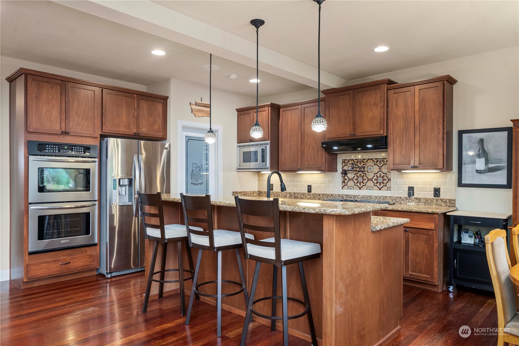 6765 Southeast 2nd Street Renton, WA 98059 - Photo 9 of 36 a kitchen with stainless steel appliances granite countertop a stove top oven a refrigerator a sink and a dining table with wooden floor