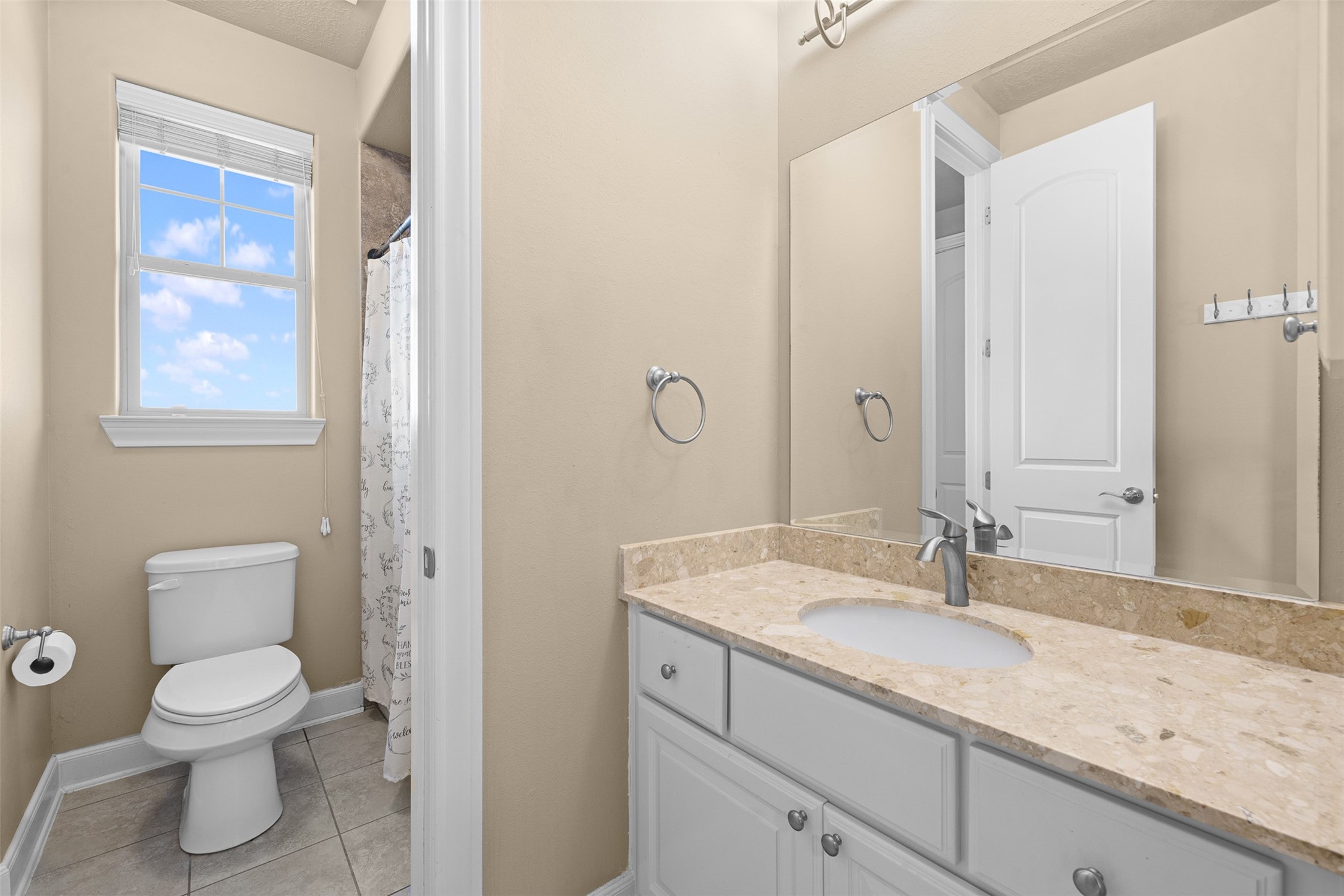 1813 Cemetery Road Bellville, TX 77418 - Photo 19 of 26 a bathroom with a granite countertop sink a toilet and a mirror