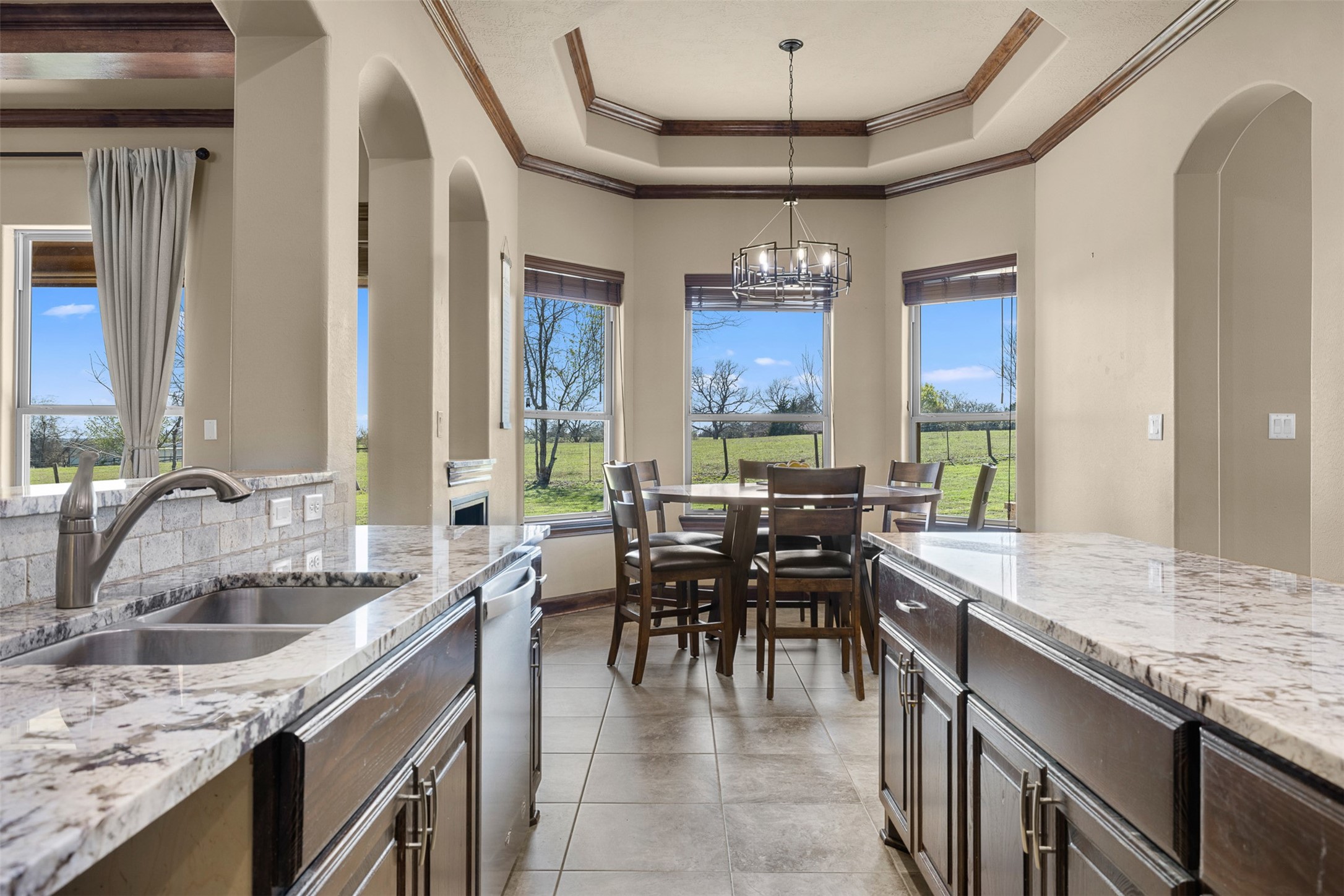 1813 Cemetery Road Bellville, TX 77418 - Photo 9 of 26 a kitchen with granite countertop a sink a counter space dining table and stainless steel appliances