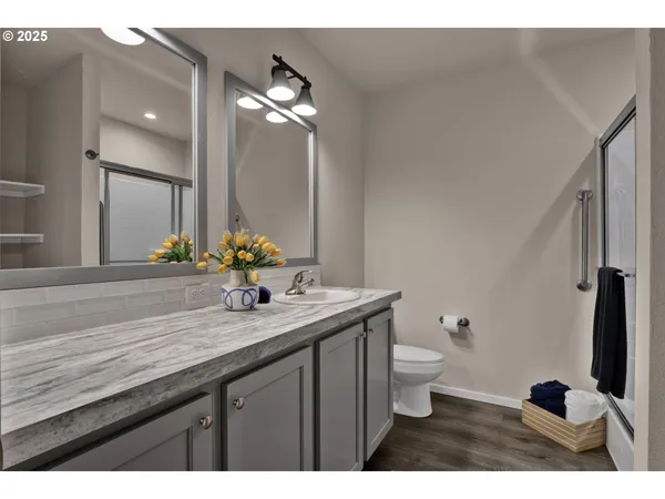 a bathroom with a granite countertop sink a toilet and a mirror