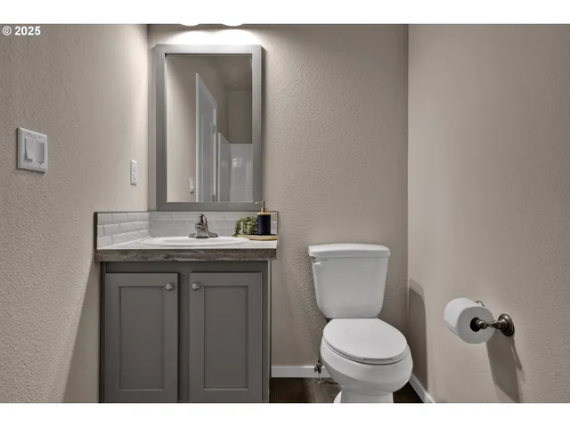a bathroom with a toilet a sink and mirror