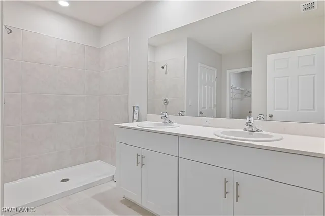 a bathroom with double sink and a mirror