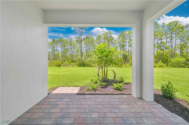 a view of two room with large trees and plants