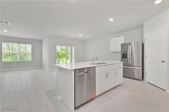 a kitchen with white cabinets and window