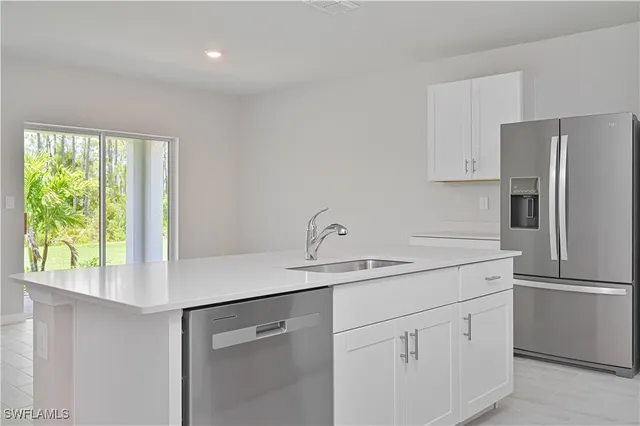 a kitchen with white cabinets and white stainless steel appliances