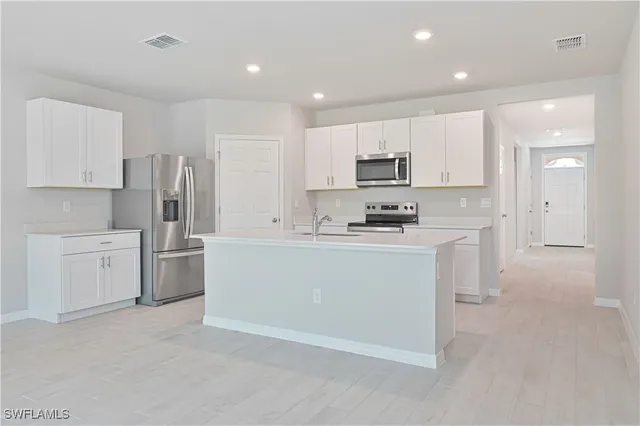 a kitchen with white cabinets and stainless steel appliances