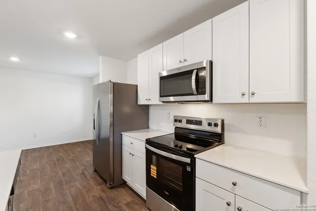 a kitchen with stainless steel appliances a stove microwave and refrigerator