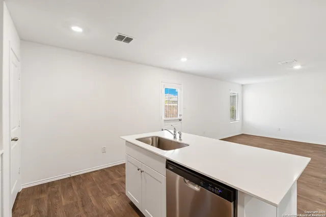 a kitchen with a sink cabinets and wooden floor